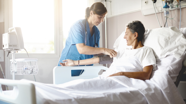 Verpleegkundige die een patiënt in het ziekenhuis begeleidt