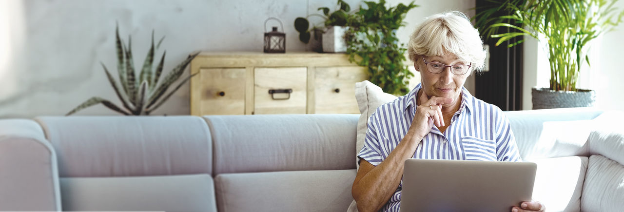 Lezende vrouw van middelbare leeftijd, verwijzend naar Veelgestelde vragen.